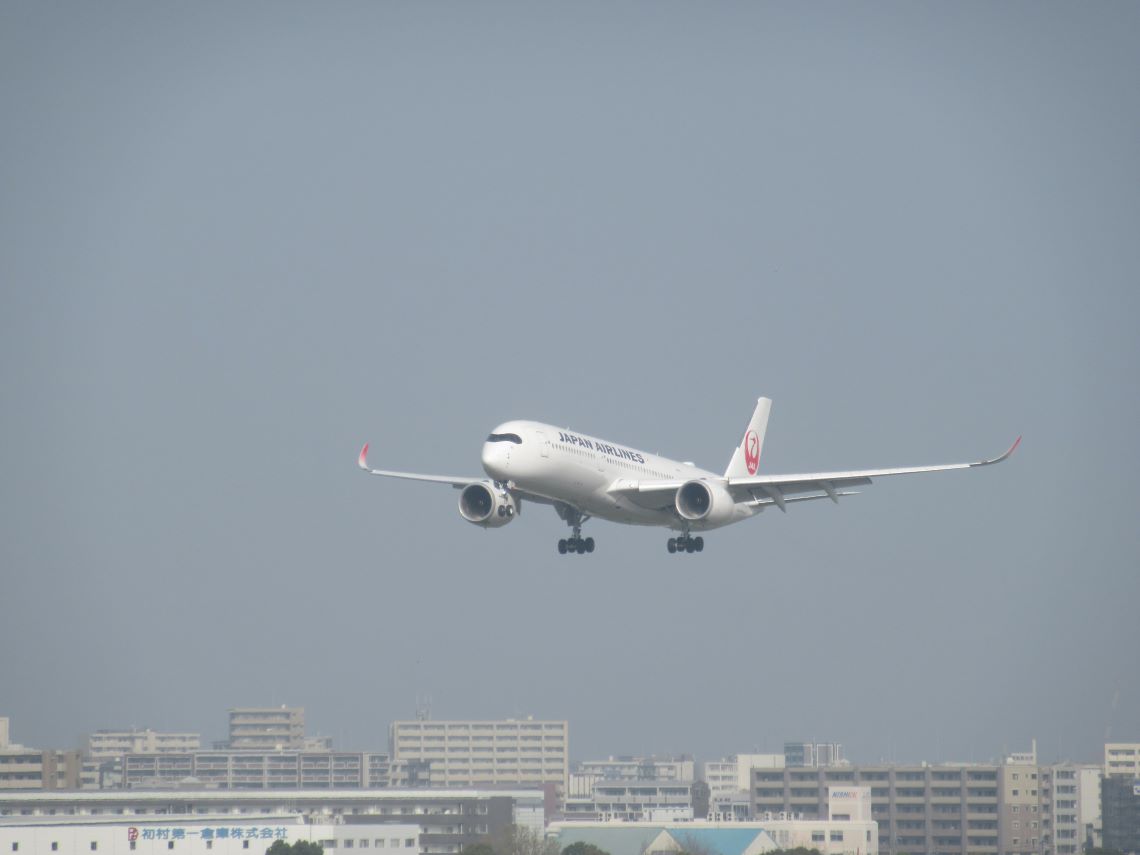 街なかにある福岡空港で着陸しようとしている日本航空(JAL)の飛行機。