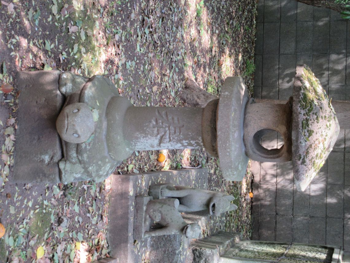 長崎市・松森天満宮にある亀趺（土台が亀の像になっている灯籠）と後ろにいるお稲荷さんの狐像。